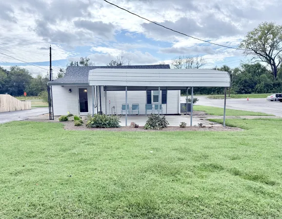 a view of a house with a yard and sitting area