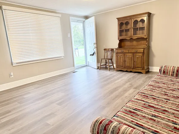 a view of a bedroom with wooden floor and furniture