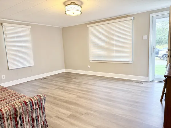 a view of a bedroom with wooden floor and a window