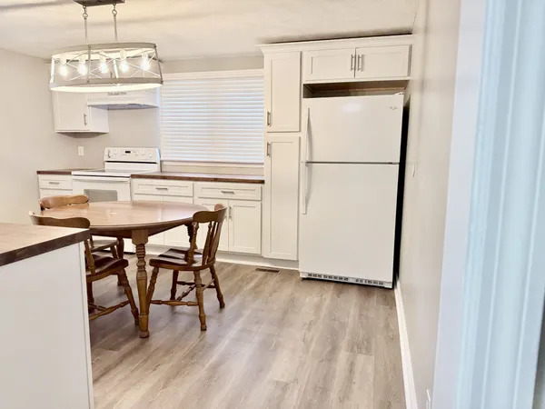 a kitchen with kitchen island a dining table chairs and wooden floor