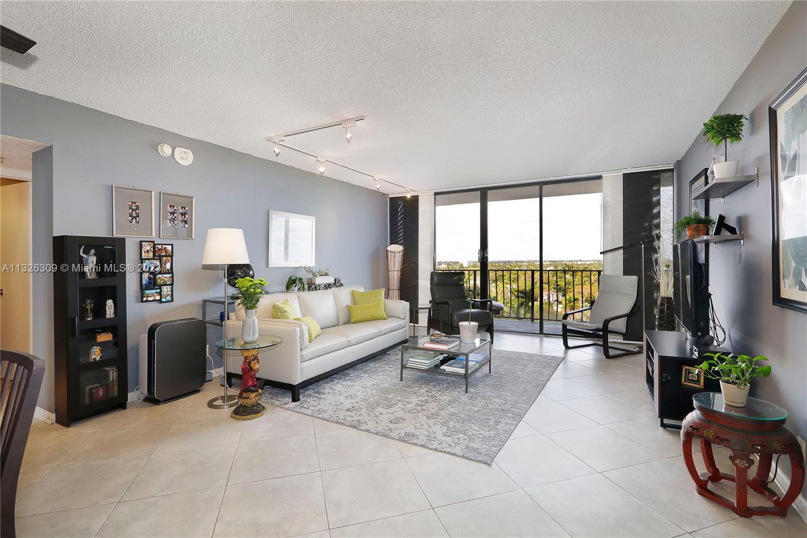 780 Northeast 69th Street, Unit 1004 Miami, FL 33138 - Photo 2 of 41 a living room with furniture a large window and gym equipment