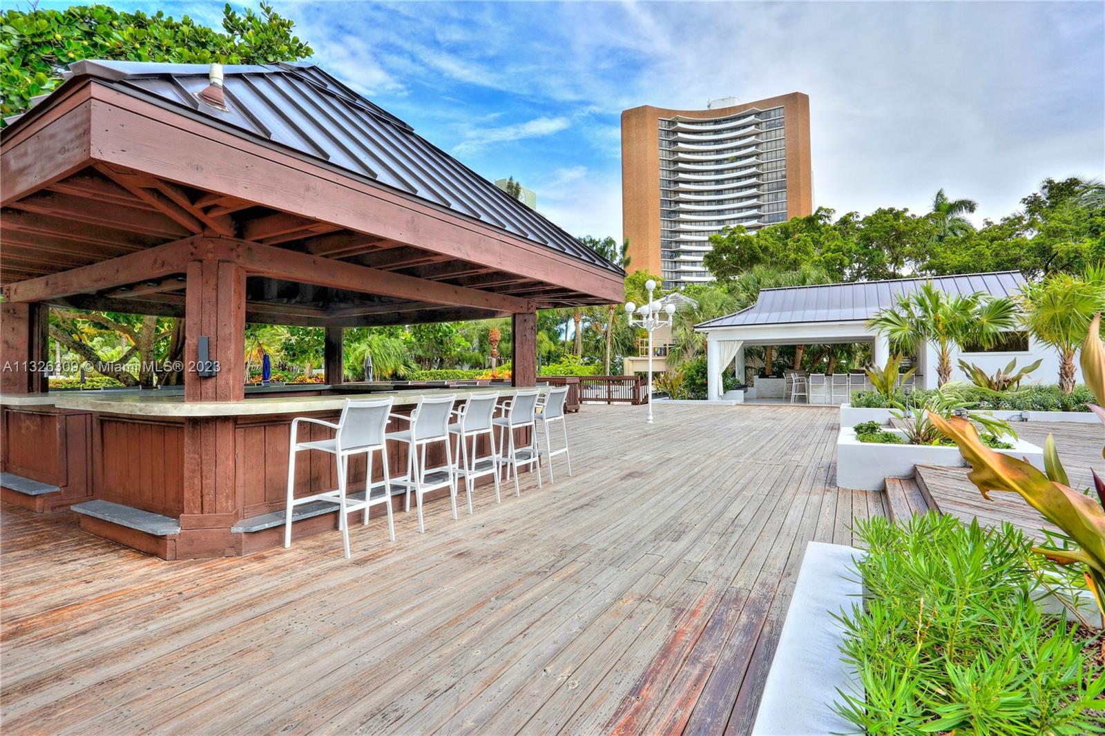 780 Northeast 69th Street, Unit 1004 Miami, FL 33138 - Photo 31 of 41 a view of a patio with table and chairs potted plants and wooden floor