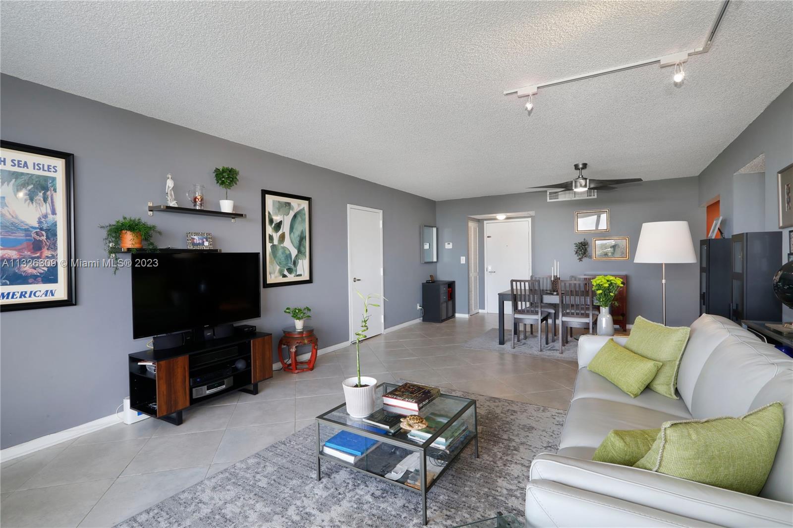 780 Northeast 69th Street, Unit 1004 Miami, FL 33138 - Photo 4 of 41 a living room with furniture and a flat screen tv