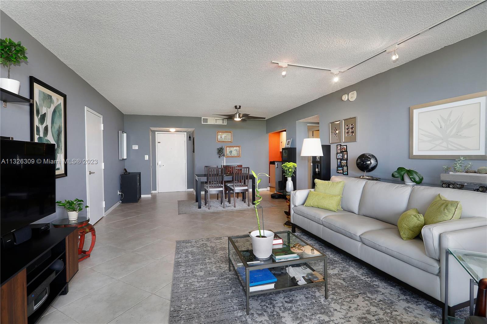 780 Northeast 69th Street, Unit 1004 Miami, FL 33138 - Photo 5 of 41 a living room with furniture and a flat screen tv