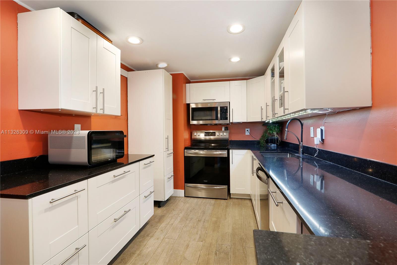 780 Northeast 69th Street, Unit 1004 Miami, FL 33138 - Photo 6 of 41 a kitchen with stainless steel appliances granite countertop a stove a sink and a microwave