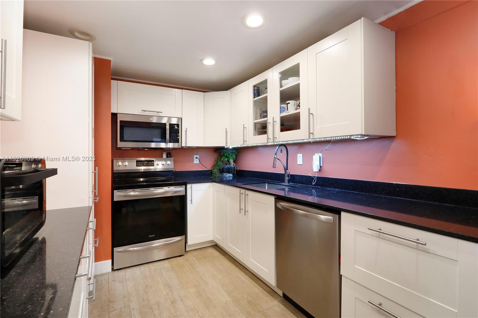 780 Northeast 69th Street, Unit 1004 Miami, FL 33138 - Photo 7 of 41 a kitchen with stainless steel appliances granite countertop a stove a sink and a microwave