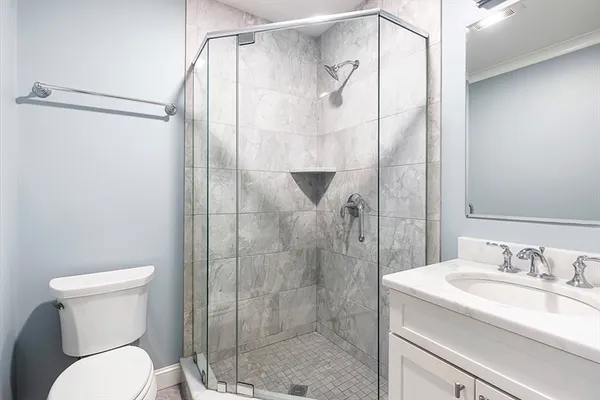 a bathroom with a granite countertop sink toilet and shower