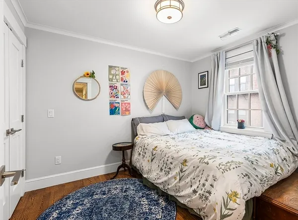 a bed sitting in a bedroom next to a window and a chandelier