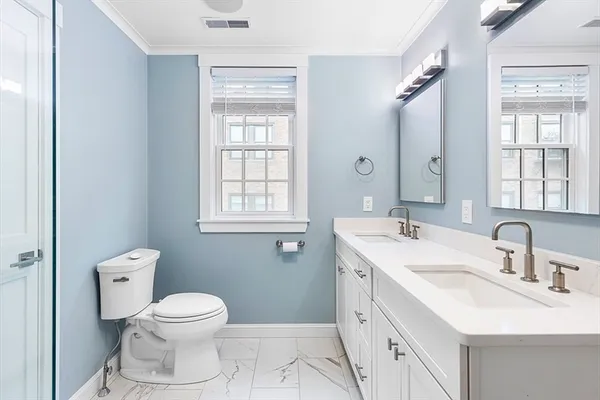 a bathroom with a toilet sink and mirror
