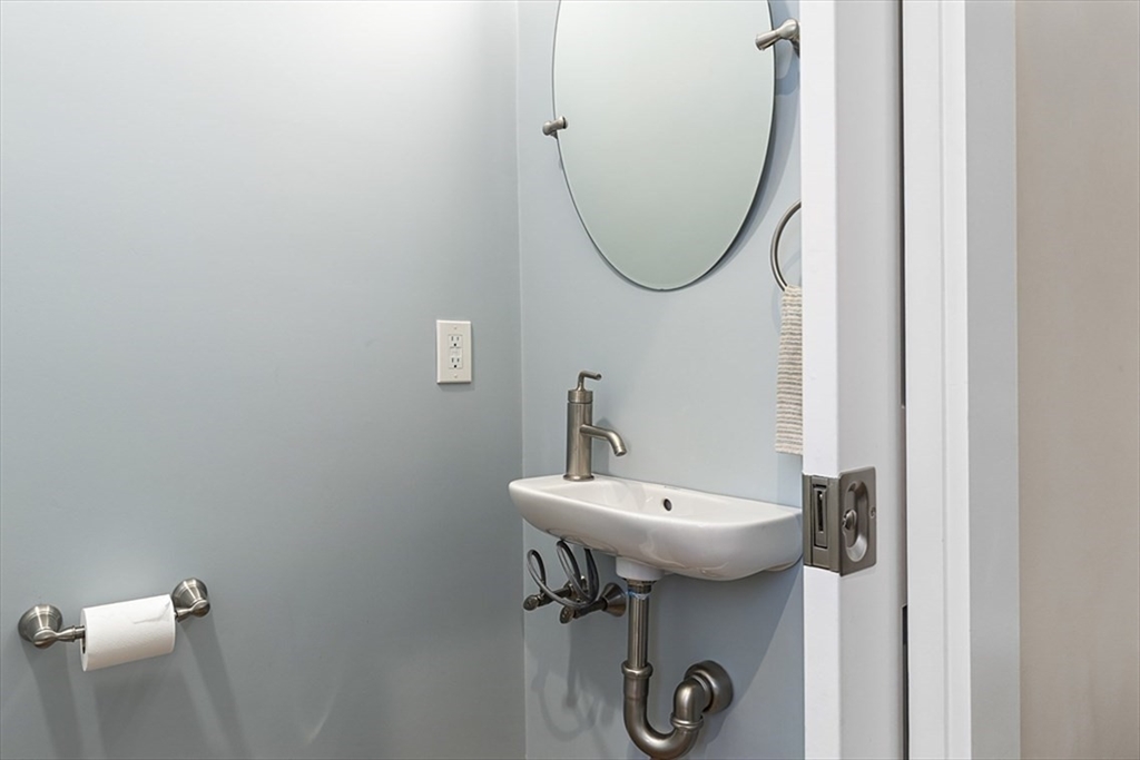 119 Highland Avenue, Unit B Somerville, MA 02143 - Photo 18 of 24 a bathroom with a sink a mirror and a toilet