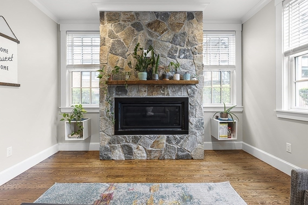 119 Highland Avenue, Unit B Somerville, MA 02143 - Photo 6 of 24 a view of an empty room with wooden floor fireplace and windows