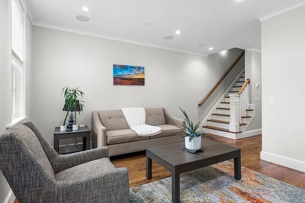 a living room with furniture potted plant and wooden floor