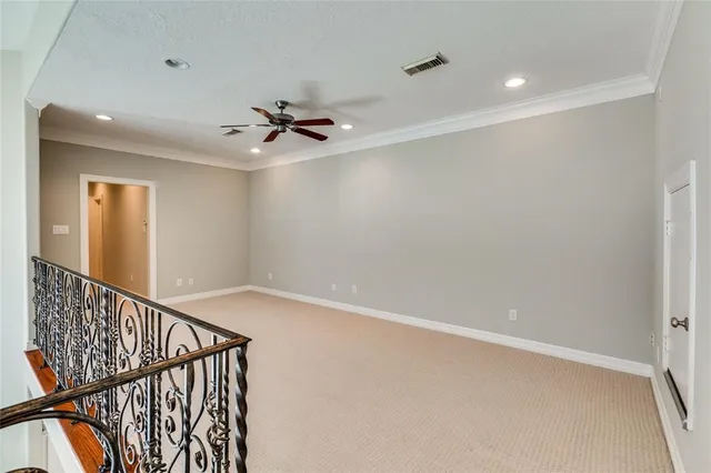 an empty room with a chandelier fan and windows