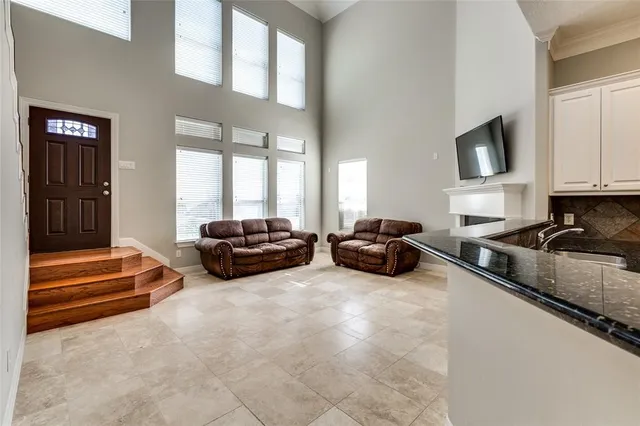 a living room with furniture a flat screen tv and a large window