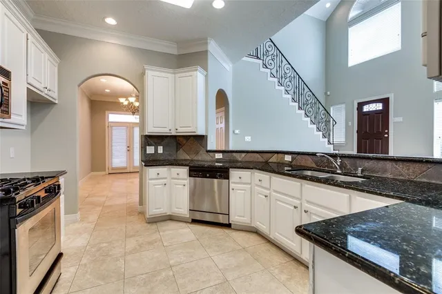 a kitchen with granite countertop a stove a sink and a microwave