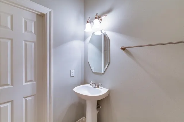 a bathroom with a sink a mirror and a light fixture