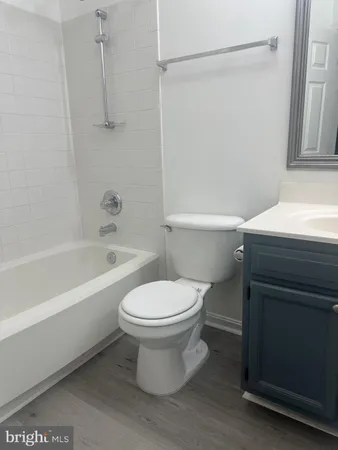 a white toilet sitting next to a bath tub