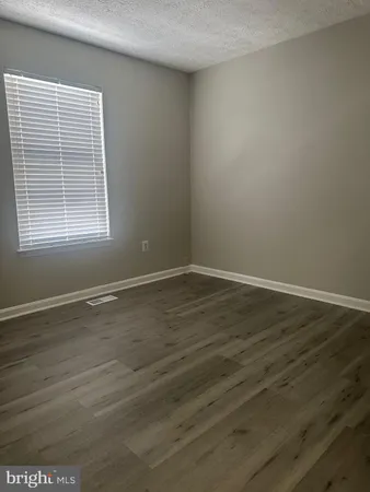 a view of a room with wooden floor and a window