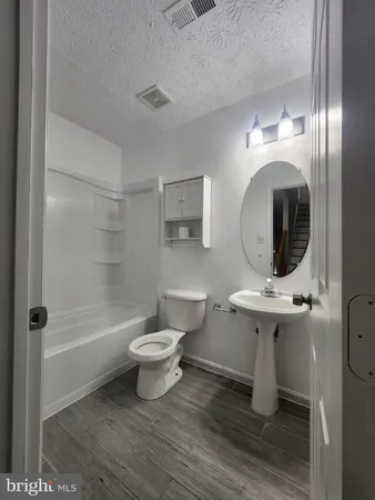 a bathroom with a sink toilet a mirror and shower