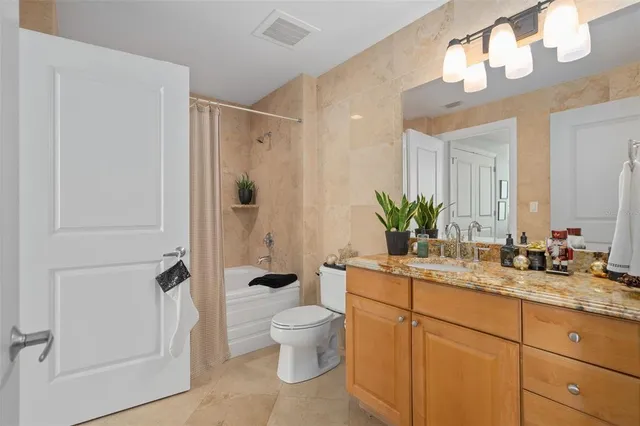 a bedroom with a large bed and a potted plant