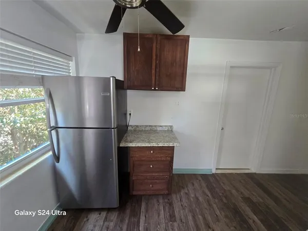 a kitchen with a refrigerator and a stove top oven