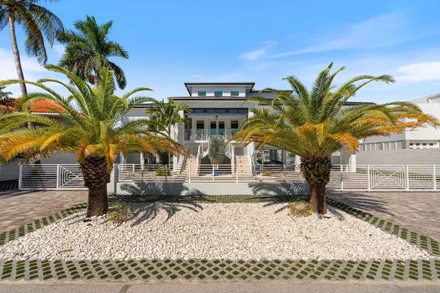 a kitchen with stainless steel appliances kitchen island granite countertop a table chairs sink and cabinets
