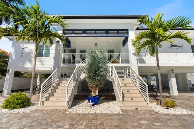 a living room with furniture a flat screen tv and floor to ceiling window