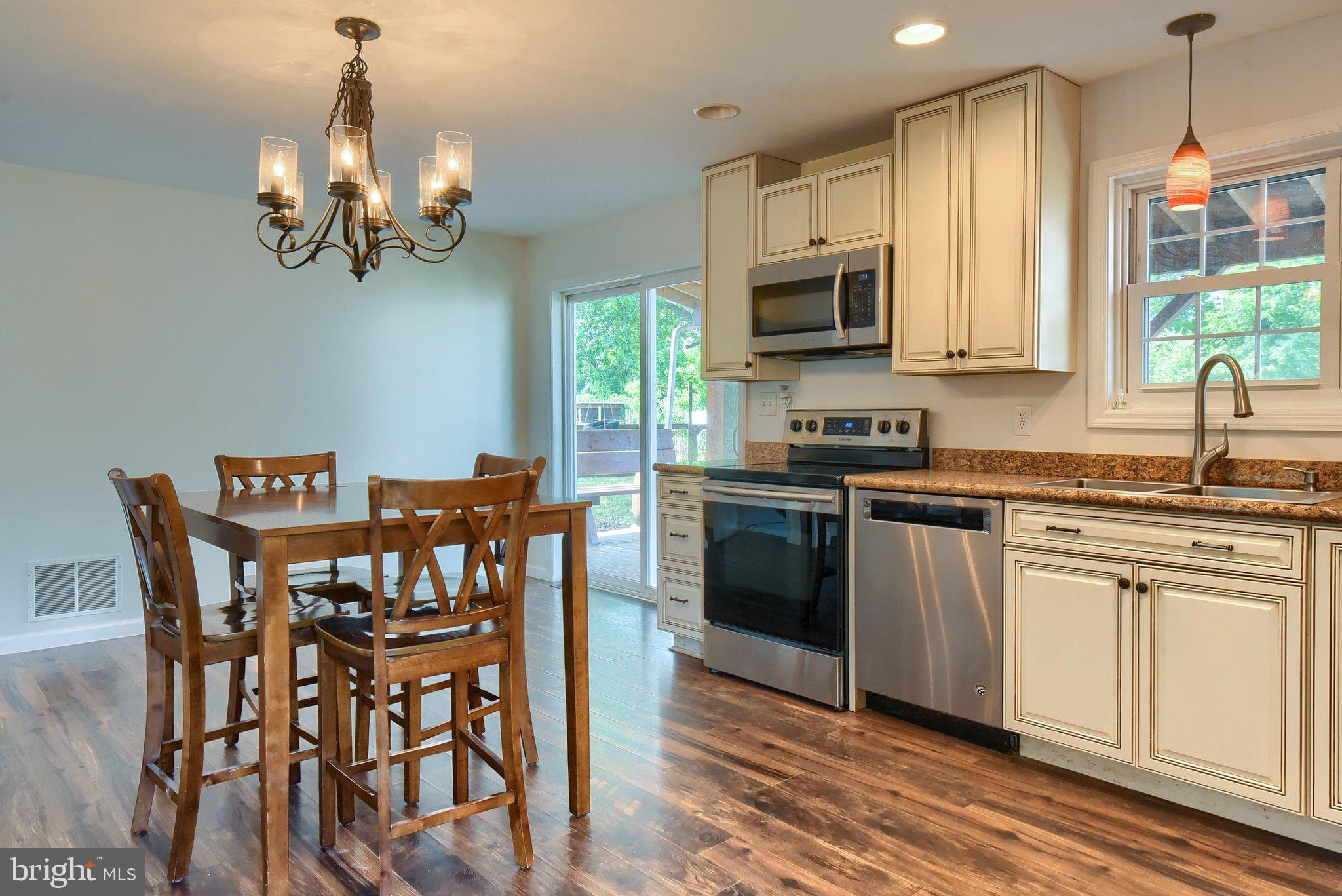 3740 Beagle Road Middletown, PA 17057 - Photo 11 of 70 a kitchen with stainless steel appliances granite countertop a kitchen island hardwood floor sink stove dining table and chairs