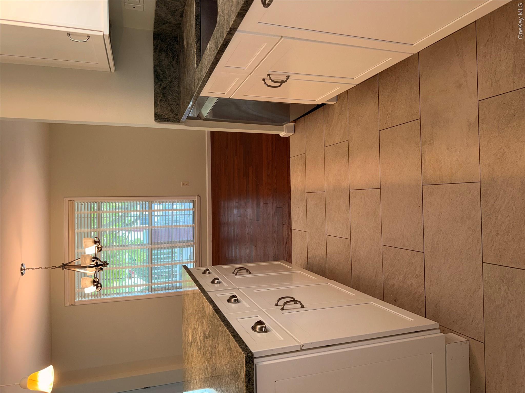1661 Old Country Road, Unit 516 Riverhead, NY 11901 - Photo 20 of 50 a kitchen with a sink a stove and cabinets