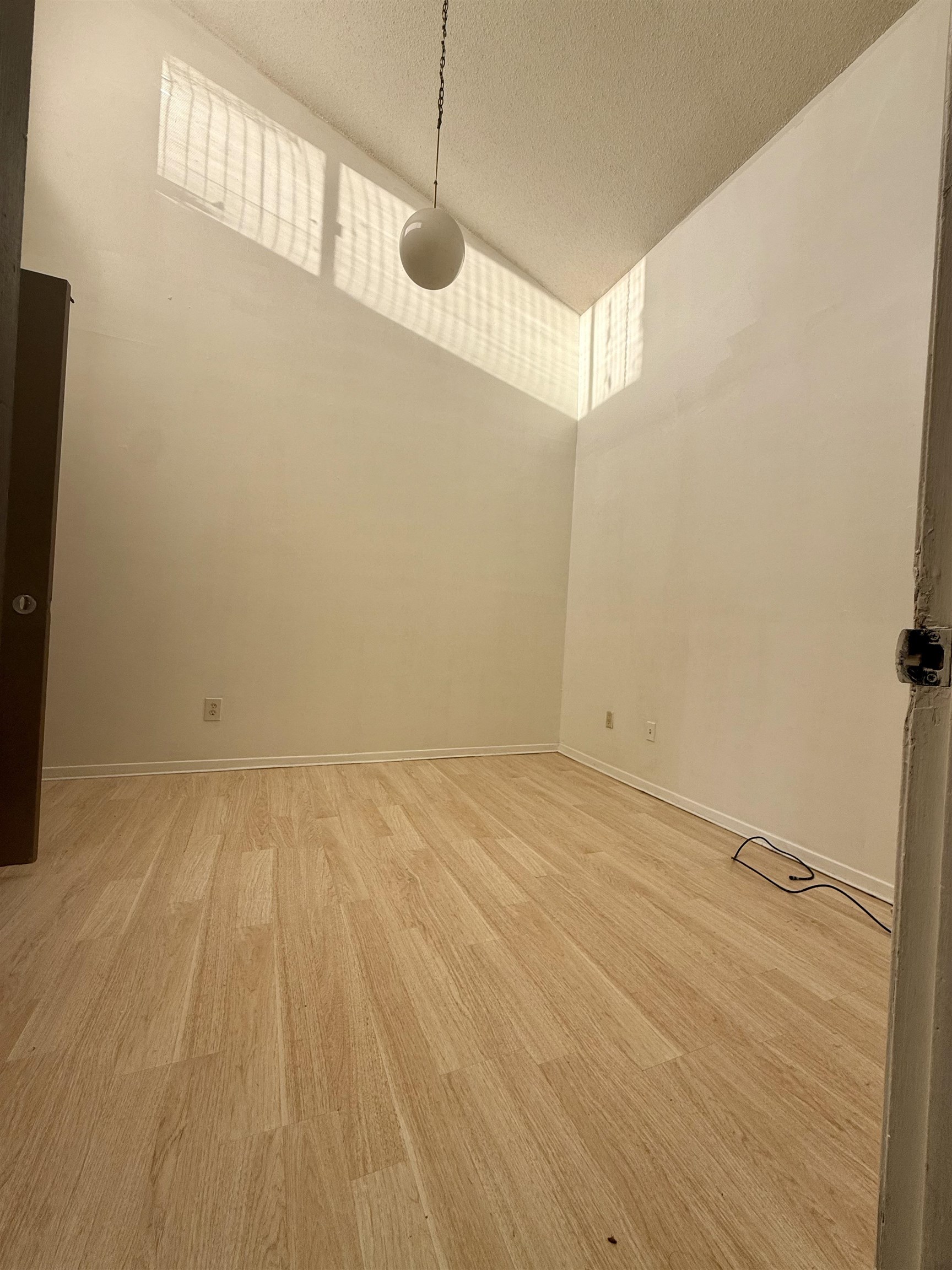 3091 Range Line Road Memphis, TN 38127 - Photo 11 of 13 Spare room featuring light wood-style floors, a textured ceiling, and lofted ceiling