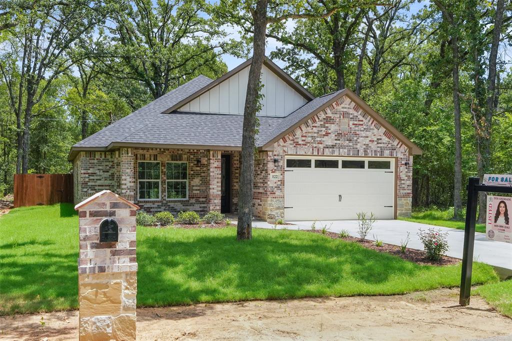 122 East Beachwood Loop Trinidad, TX 75163 - Photo 4 of 35 Brick and stone facade residence featuring a dark shingle roof, a two-car garage, and a manicured lawn