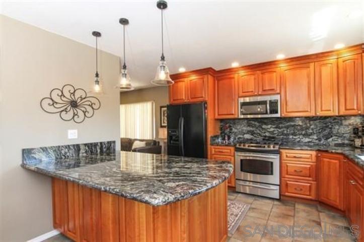 14747 Dash Way Poway, CA 92064 - Photo 20 of 23 a kitchen with stainless steel appliances granite countertop a sink a microwave oven and a counter top space