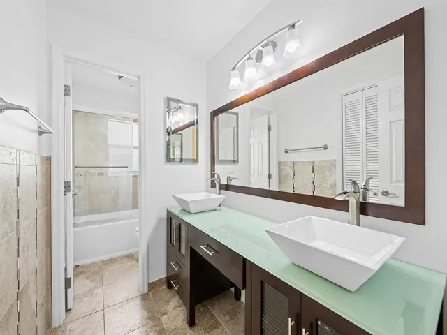 a bathroom with a sink a large mirror and a bathtub