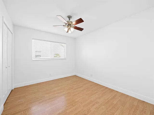 a view of a big room with wooden floor closet and windows