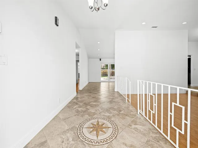 a view of a hallway with wooden floor and a large window