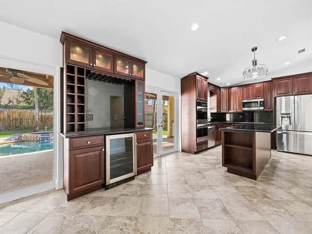 a kitchen with stainless steel appliances granite countertop a refrigerator and a stove top oven