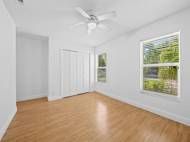 a view of an empty room with a window and a ceiling fan