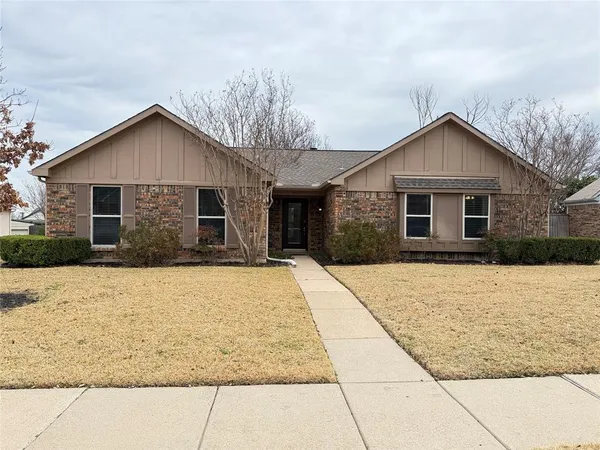 a front view of house with yard and trees around