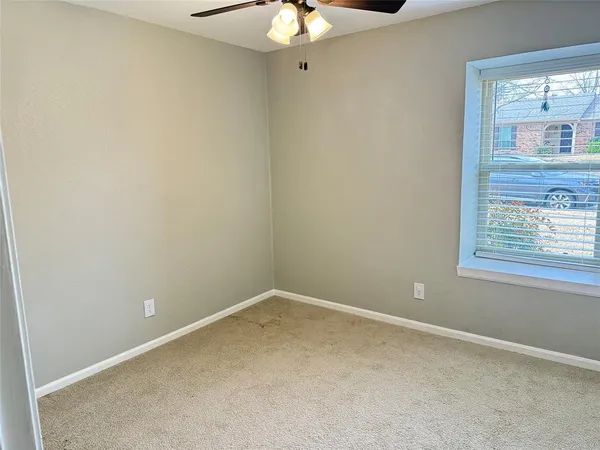 an empty room with windows and fireplace