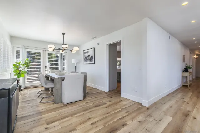 a dining room with furniture a chandelier and wooden floor