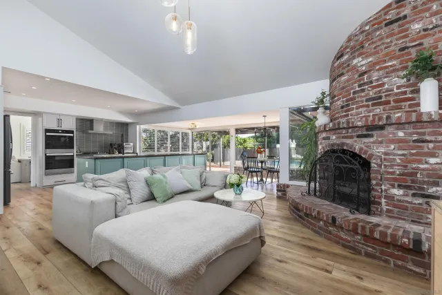 a living room with furniture a fireplace and a floor to ceiling window
