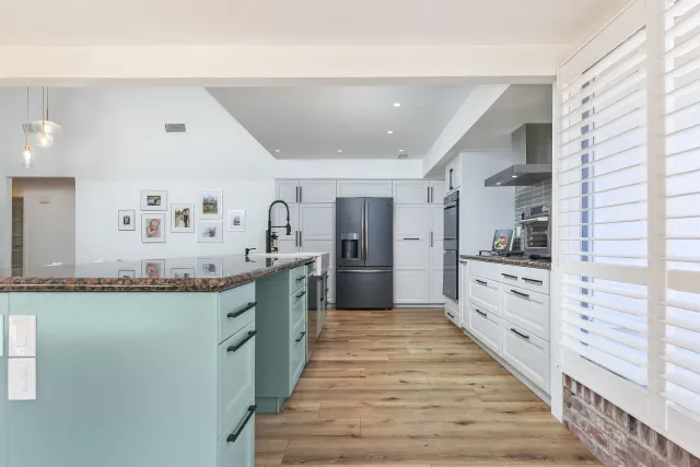 a large kitchen with stainless steel appliances kitchen island granite countertop a large counter top and sink