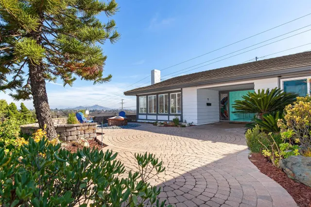 a front view of a house with a yard and potted plants