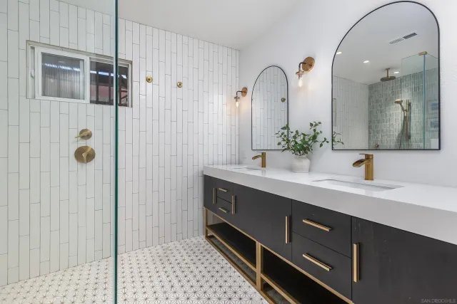 a spacious bathroom with a double vanity sink a mirror and shower