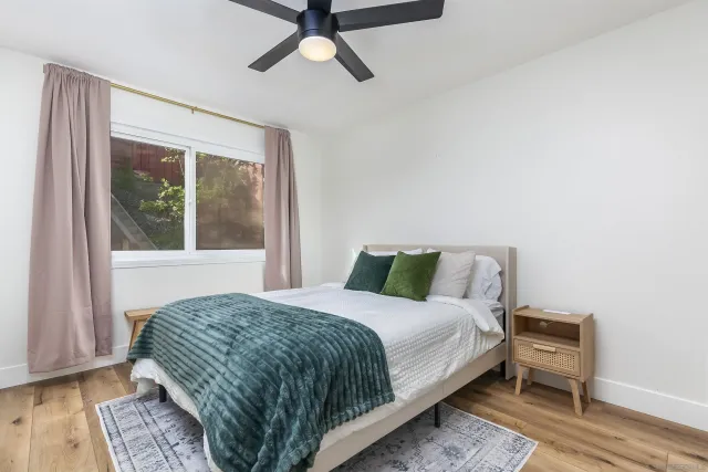 a bedroom with a bed and wooden floor