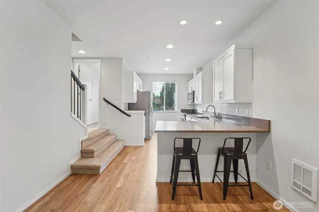a kitchen with stainless steel appliances granite countertop a dining table chairs and granite counter tops