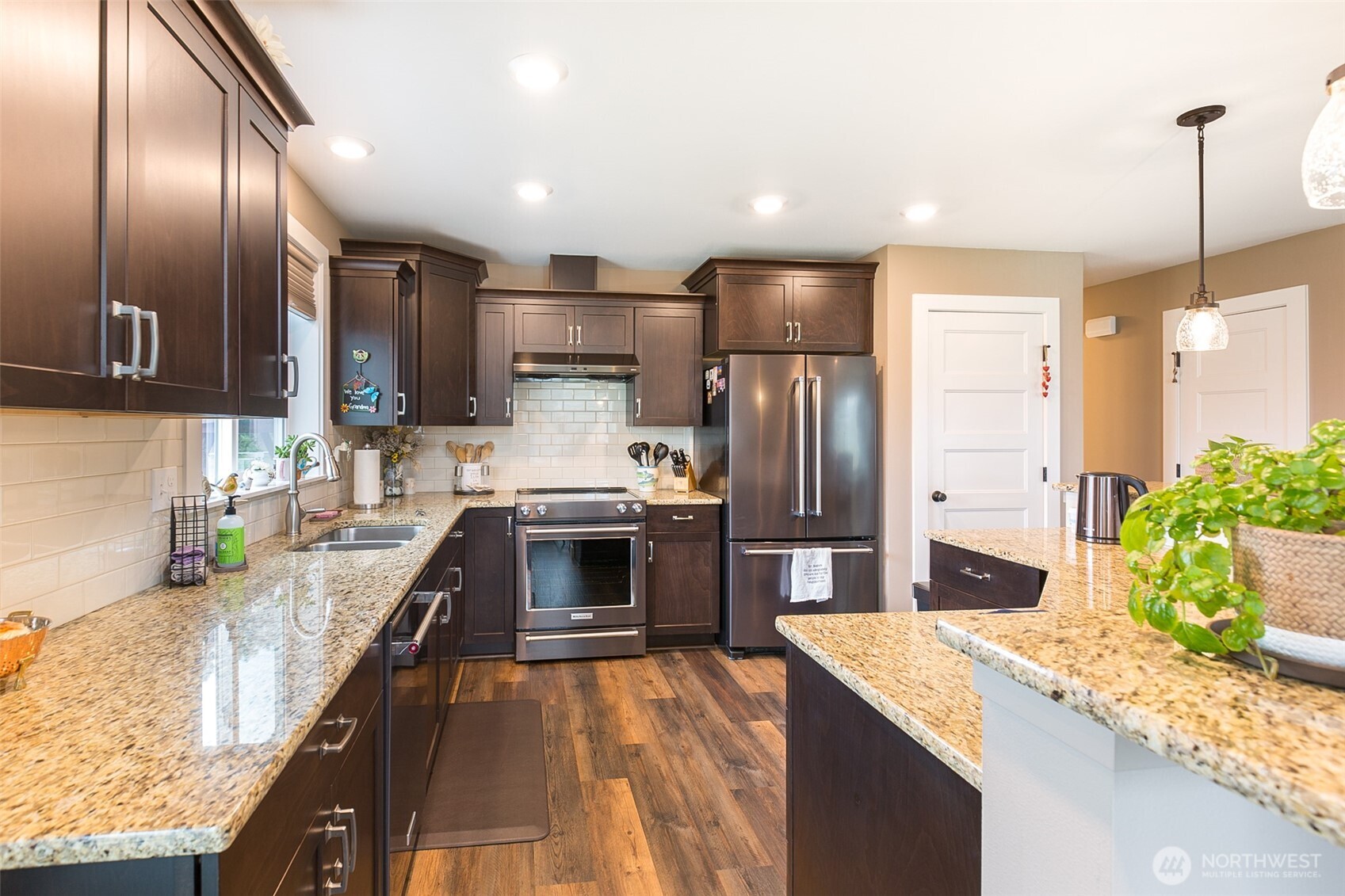 41 Victoria View Street Sequim, WA 98382 - Photo 7 of 40 a kitchen with stainless steel appliances kitchen island granite countertop a sink refrigerator and cabinets
