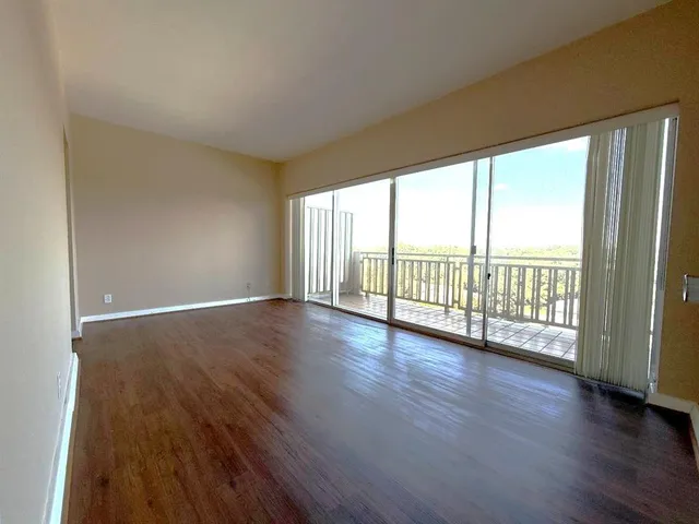 a view of empty room with wooden floor and fireplace