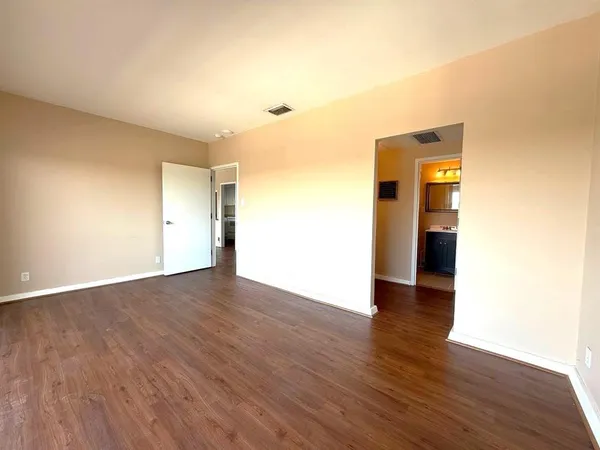 a view of a hallway and wooden floor with windows