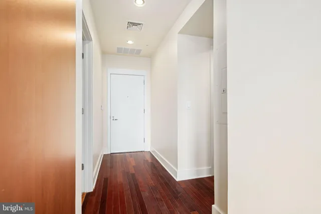 a view of a hallway with wooden floor